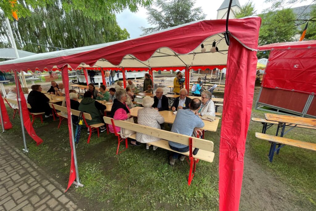 Menschen sitzen unter einem Zelt auf dem Frohlinder Familienfest. Menschen sitzen unter einem Zelt auf dem Frohlinder Familienfest.