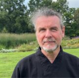 Michael Steinmetz steht auf einer Wiese im Emscherpark.