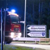 Ein Feuerwehrwagen fährt an einem Schild zur Bleiberg-Kaserne der Bundeswehr in Mechernich vorbei.