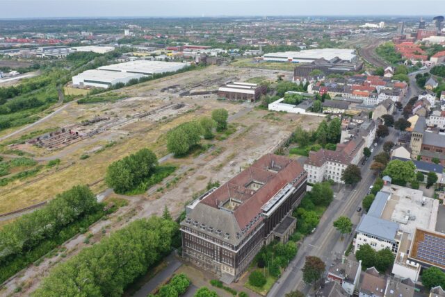 So sieht im Sommer 2024 das weitgehend freigeräumte HSP-Gelände von oben aus. Vorne: die ehemalige Hoesch-Zentrale an der Rheinischen Straße, die bis 2011 als Versorgungsamt genutzt wurde. Seitdem steht sie leer.