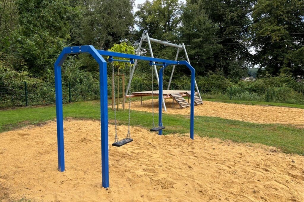 Eine Schaukel und eine Seilbahn auf einem Spielplatz Eine Schaukel und eine Seilbahn auf einem Spielplatz