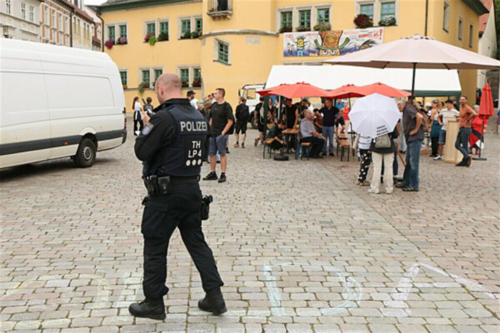 Ein Polizist steht bei einer Linken-Demonstration gegen eine Wahlkampfveranstaltung der AfD Thüringen auf dem Marktplatz.