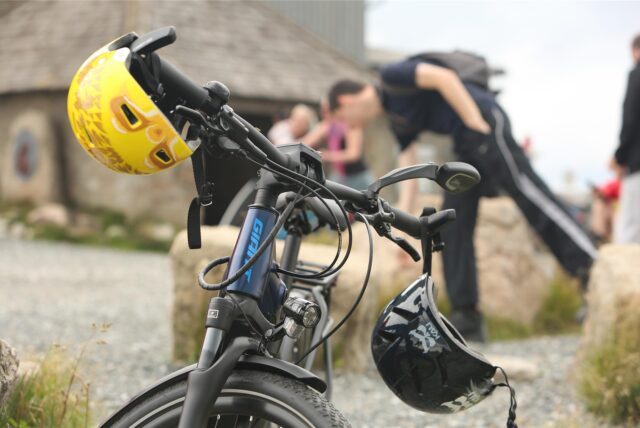 Helme hängen an einem Fahrrad, das auf dem Brocken steht.