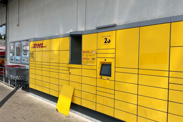 Eine abgetrennte Tür steht vor der Packstation von DHL in Dortmund-Derne, in der ein Junge eingesperrt worden war.