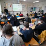 Schüler sitzen vor ihren Tablets in einem Klassenzimmer.