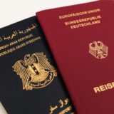 Ein syrischer und ein deutscher Reisepass liegen symbolisch für die doppelte Staatsangehörigkeit nebeneinander.