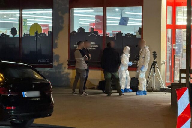 Einsatzkräfte der Polizei stehen vor einem Supermarkt im Münchner Stadtteil Sendling.