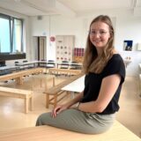 Maria Hoppe sitzt auf dem Pult in ihrem Klassenzimmer 1.23 der Grundschule Herten-Mitte.
