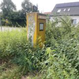 Gelber Briefkasten auf einer Wiese
