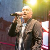 Schlagersänger Olaf Henning steht auf einer Bühne, hält ein Mikrofon in seiner rechten Hand und singt.