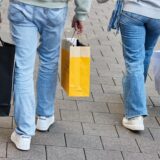 Eine Frau und ein Mann tragen mehrere Einkaufstüten am verkaufsoffenen Sonntag.