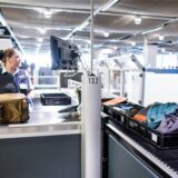 Eine Flughafenmitarbeiterin arbeitet am Flughafen Düsseldorf bei der Sicherheitskontrolle.