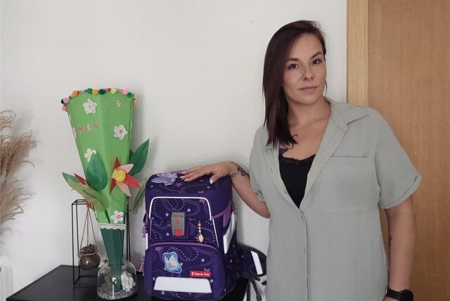 Kim-Jennifer Schröder steht neben Tornister und Schultüte ihrer Tochter