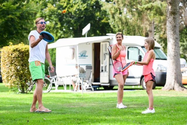Eine Familie spielt auf einem Campingplatz.