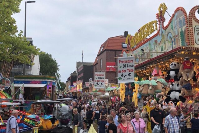 Besucher gehen auf der Bartholomäuskirmes in Lütgendortmund an den Ständen vorbei.