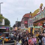 Besucher gehen auf der Bartholomäuskirmes in Lütgendortmund an den Ständen vorbei.