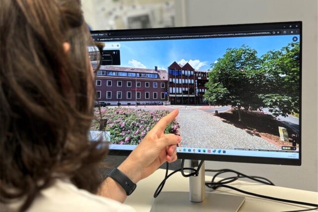 Ein Mann zeigt auf einen Computer-Monitor