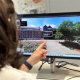 Ein Mann zeigt auf einen Computer-Monitor