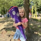 Ein Mädchen, das eine Schultüte hält.