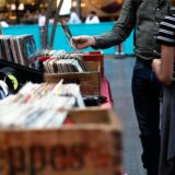Ein Paar stöbert auf einem Trödelmarkt in NRW durch Schallplatten und Zeitschriften.