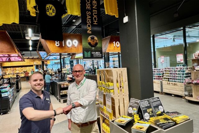 Marktleiter Sascha Bien und Stefan Grubendorfer stehen vor der neuen BVB-Ecke im Marktkauf in Dortmund-Aplerbeck: Die steht direkt vor der Kasse 09.