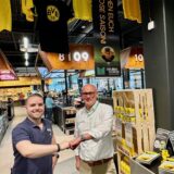 Marktleiter Sascha Bien und Stefan Grubendorfer stehen vor der neuen BVB-Ecke im Marktkauf in Dortmund-Aplerbeck: Die steht direkt vor der Kasse 09.