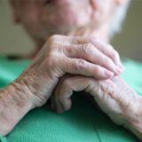 Eine Seniorin faltet ihre Hände.