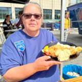 Fisch-Sommelière Andrea Niesel zeigt auf dem Wochenmarkt in Dortmund einen Teller mit Backfisch.
