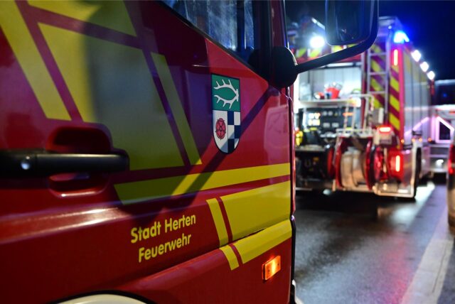 Einsatzfahrzeuge der Hertener Feuerwehr stehen nachts bei einem Einsatz auf einer Straße.(Symbolbild)