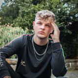 TikTok-Star Tobii FH im schwarzen Shirt guckt ernst in die Kamera.