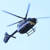 Ein fliegender Polizeihubschrauber von unten fotografiert.