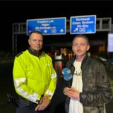 Reporter Phillipp Pohl mit dem Einsatzleiter der Polizei – im Hintergrund erkennt man die Unfallstelle