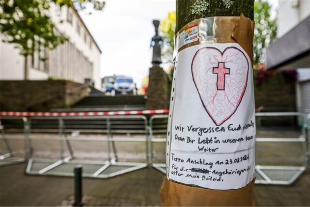 Nach der Messerattacke auf dem Solinger Stadtfest hängt ein selbstgeschriebenes Beileidsschreiben mit einem Herz und einem Kreuz an einem Baum in der Nähe des Tatorts in der Solinger Innenstadt.