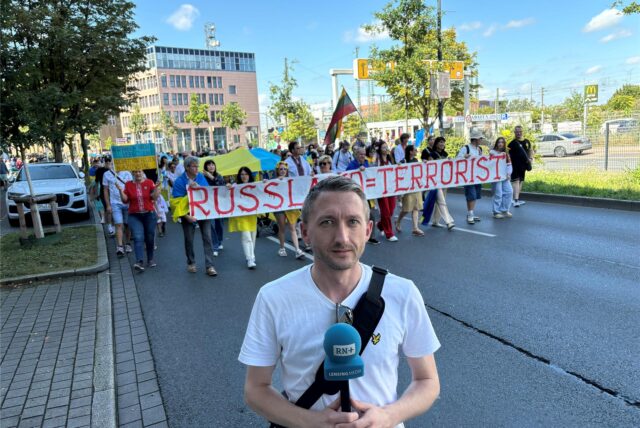 Reporter Philipp Pohl – im Hintergrund der Demonstrationszug.