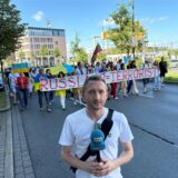 Reporter Philipp Pohl – im Hintergrund der Demonstrationszug.