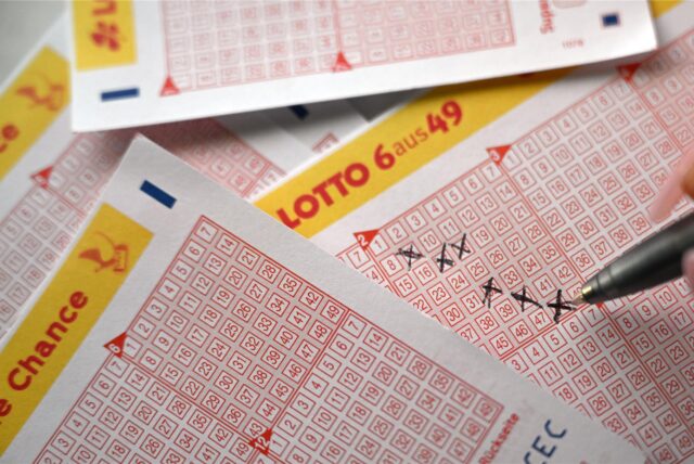 Eine Spielerin füllt einen Lottoschein aus.
