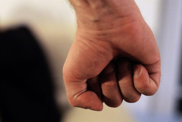 Ein Mann ballt seine Hand zur Faust.