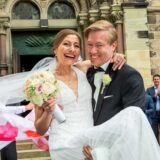 Vor dem Eingang der Kirche St. Martinus trägt Markus Hilfert seine Braut Celine Gallwas auf Händen.