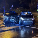 Zwei schwer demolierte Pkw stehen bei Dunkelheit auf einer nassen Straße.