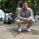 Jan Heisig-Schwarz hockt vor einem Schlagloch auf einem Bürgersteig in der Saarlandstraße in Dortmund.