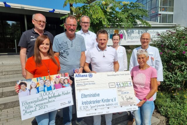 Mehrere Personen halten Spendenschecks hoch.