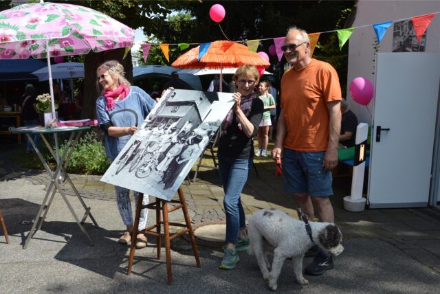 Anne Trösken (r.), die „Kunst Anne Bude“ organisiert, und ihre Schwester Christel Trösken. In den Händen halten sie ein altes Foto des Fotografen Helmut Orwat, das an der Trinkhalle von Emmy Olschewski aufgenommen wurde.