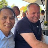 Zwei Männer stehen an einem Bierwagen.