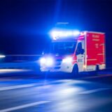 Ein Rettungswagen der Feuerwehr fährt mit Blaulicht durch eine Straße