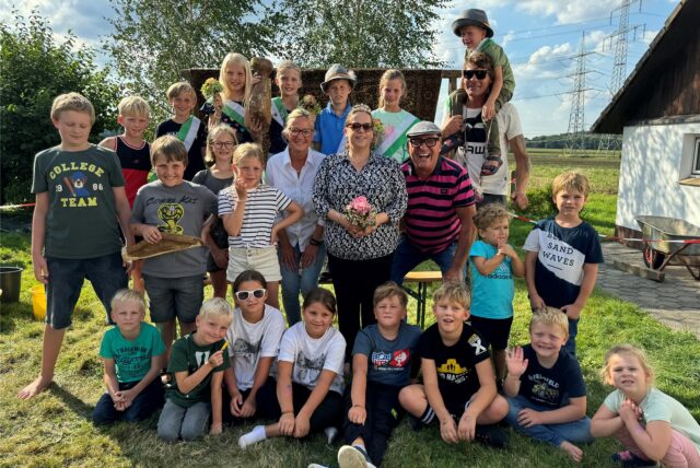 Kinder und Erwachsene stehen in einer Gruppe zusammen.