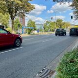 Autos fahren auf dem Wall in Dortmund an der Einfahrt zur Tiefgarage Friedensplatz vorbei.