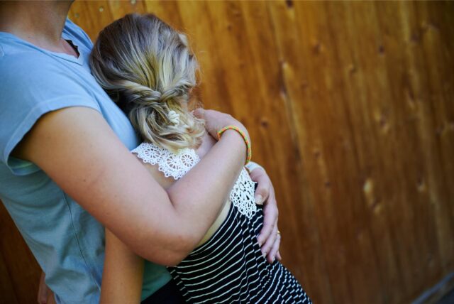 Ein Mädchen wird von seiner Mutter in den Arm genommen und getröstet.