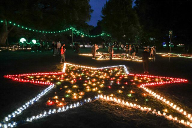 Besucher bestaunen bunt beleuchtete Sterne beim Lichterfest im Westfalenpark Dortmund.