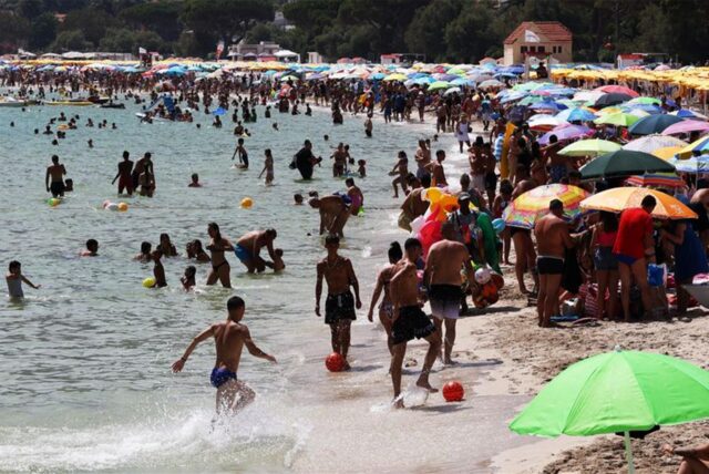 Zahlreiche Menschen sind an einem Strand in Italien zu sehen.
