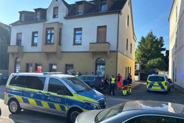 Polizei und Rettungsdienst stehen nach einem Messerangriff unter Nachbarn an einem Mehrfamilienhaus in Recklinghausen